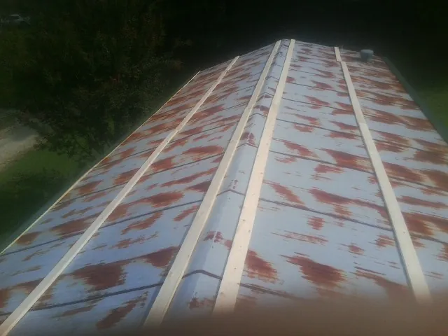 Rusted metal roof panels with new wood purlins before replacement — Storm Damage Roof Repair in Bond by Roofing Brothers