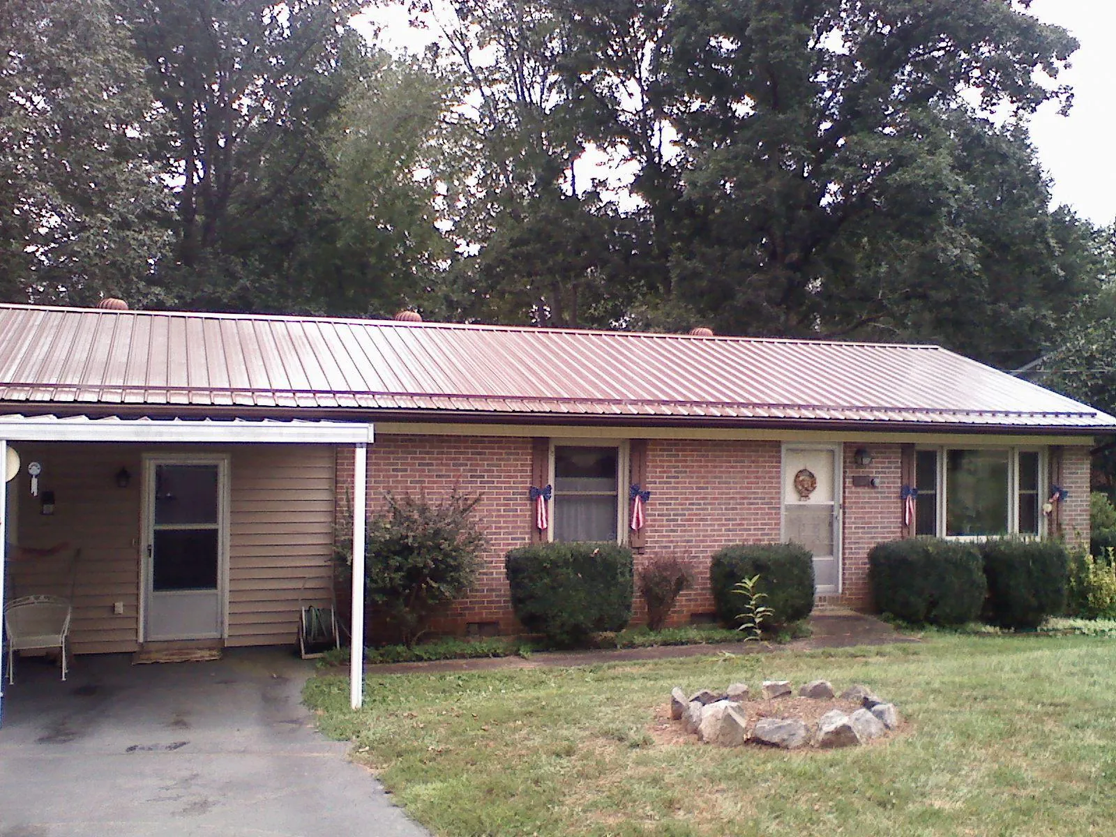 Bronze metal roof and carport on a brick ranch home — Roof Repair work by our crew in Bond